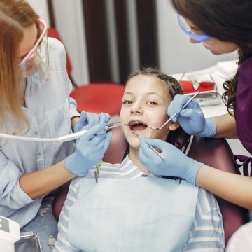 Cute little lady in the dentist's office. Woman in a uniform. Doctor with a patient